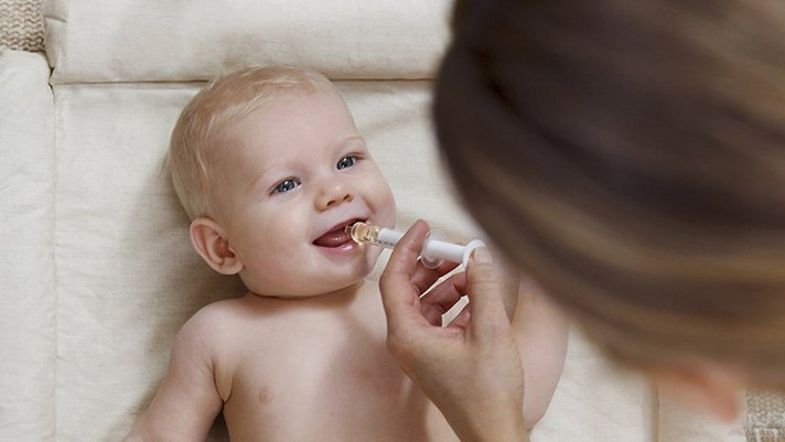 Baby Lebertran mit einer Dosierspritze geben